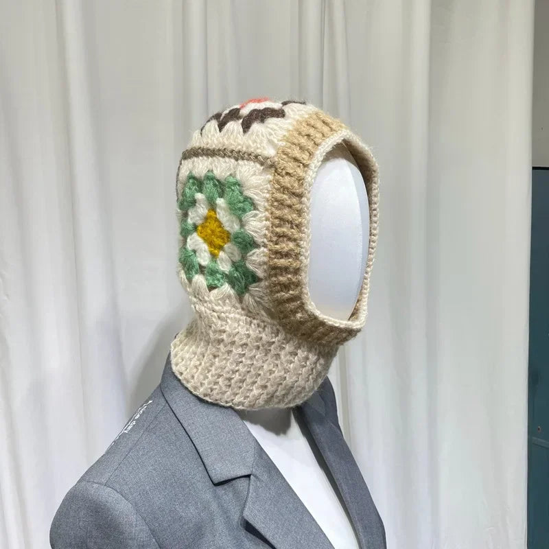 Crocheted white knit balaclava with floral design showcased on mannequin head